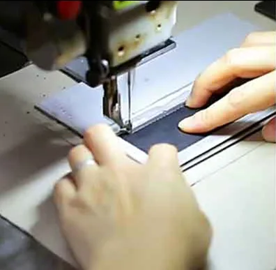 Close-up of industrial double-needle sewing machine executing precise dual-thread stitching on waterproof Oxford fabric for premium automotive storage organizers